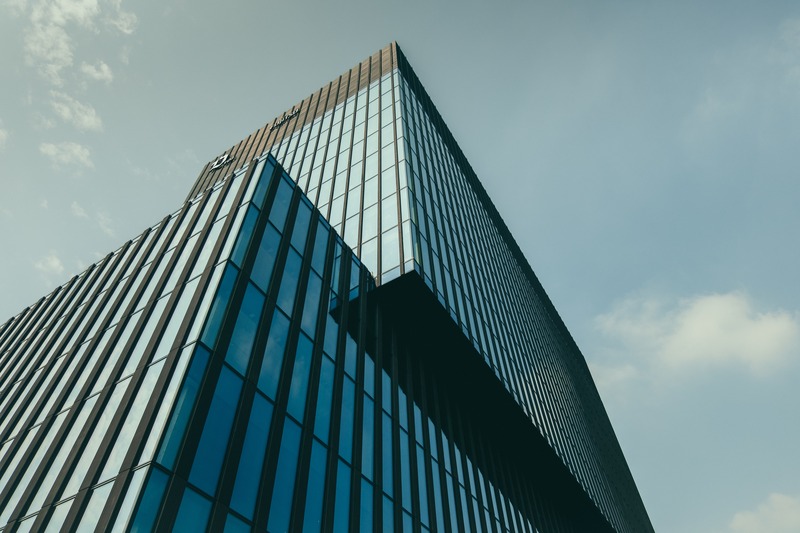 low-angle-view-building-glass-facade-beautiful-cloudy-sky (1)